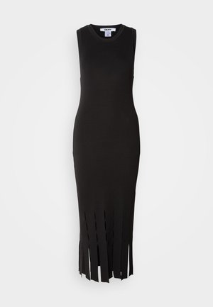 Musta, hihaton neulemekko, jossa on tiukka siluetti ja lehvämäinen yksityiskohta helman kohdalla. Sileä tekstuuri ja minimalistinen muotoilu.