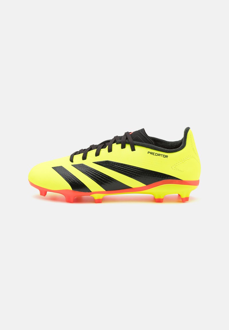Scarpa da calcio gialla con accenti neri e tre strisce diagonali; presenta una superficie texturizzata e una suola rossa brillante. Marca: Predator.