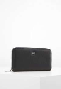 Portafoglio in pelle nera con superficie testurizzata, dotato di chiusura con zip e di un logo argentato sulla parte anteriore. Forma rettangolare, design slim.