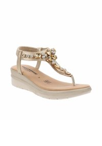 Sandalo infradito beige con tacco a forma di zeppa, caratterizzato da accenti metallici e gioielli decorativi sulla fascia anteriore, suola in gomma e soletta imbottita.