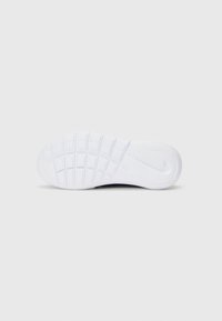 Semelle en caoutchouc blanc de sneaker avec un motif de grip texturé et un détail de logo, design plat, comportant des picots de traction rectangulaires pour la stabilité.