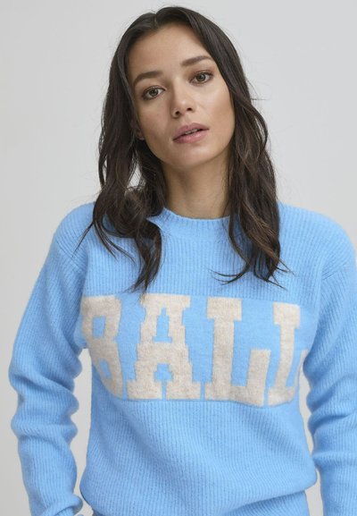Lys blå ullgenser med en hvit blokkbokstavdesign som staver "BALL." Ribbestruktur og rund hals.