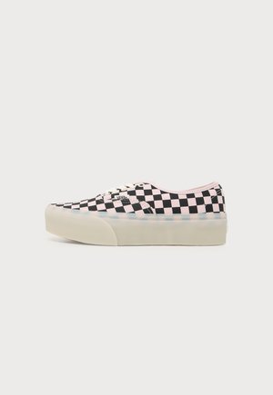 Niskie buty sportowe Vans z czarno-różowym wzorem w kratkę i grubą białą gumową podeszwą, pokazane z boku na białym tle.