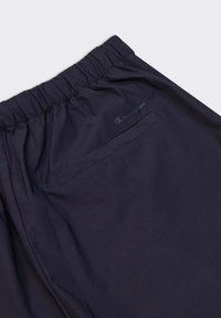 Pantaloni sportivi navy con vita elasticizzata, dotati di una tasca posteriore cucita e di un logo discreto. Realizzati in materiale leggero e liscio.