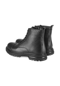 Zwarte leren enkellaarsjes met veters en zijritsen, voorzien van een ronde neus en een gestructureerde rubberen zool met opvallende noppen.