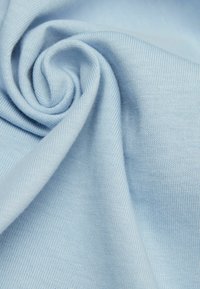 Světle modrá tkanina s jemnou strukturou, která má hladký, tkaný vzor a vzhled srolovaných částí, což naznačuje pružnost a splývavost.