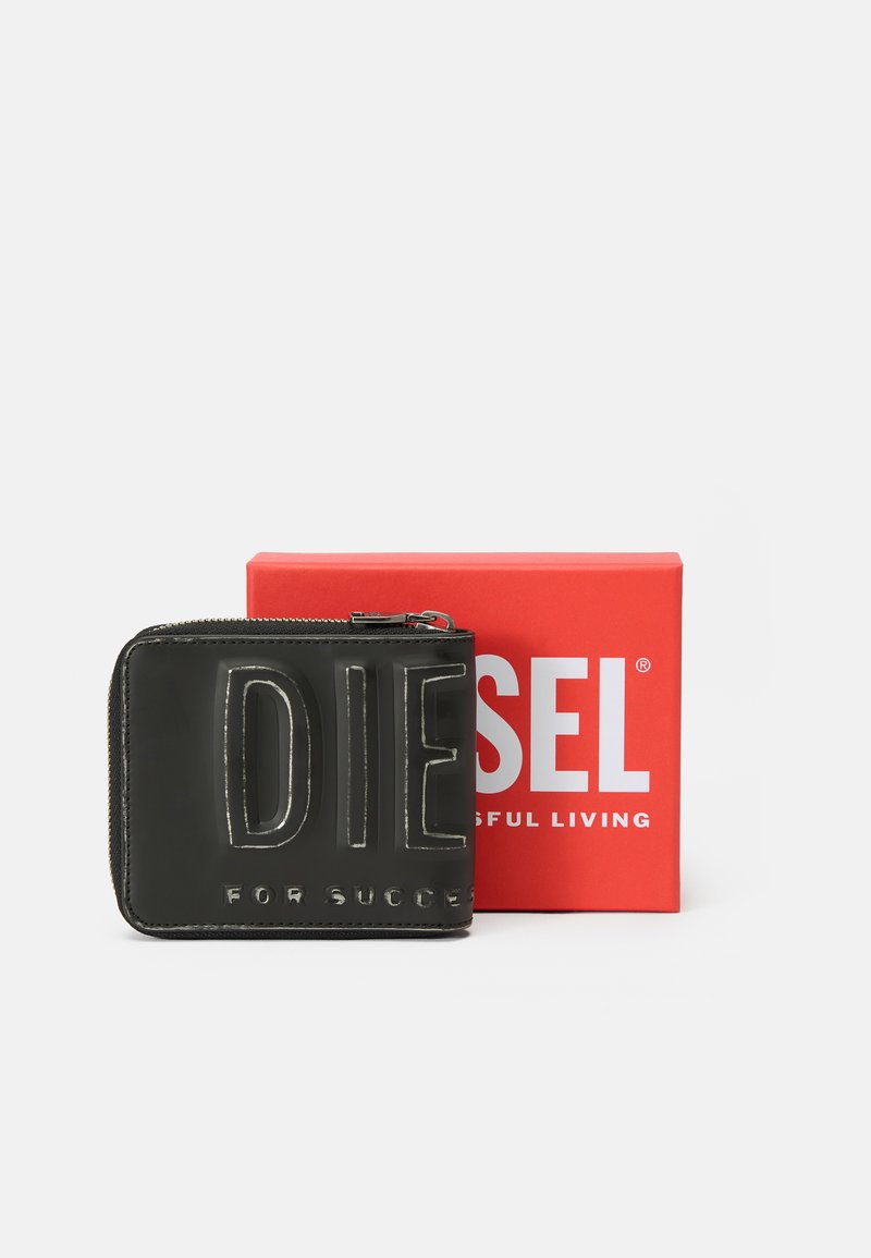 Schwarzes Reißverschluss-Portemonnaie mit geprägtem Text "DIESEL FOR SUCCESSFUL LIVING", präsentiert vor einer roten Diesel-Box.