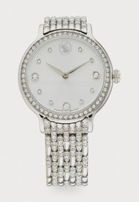 Silver wristwatch with a sparkling bezel and diamond-like accents. Features a white face, three hands, and a multi-strand link bracelet.