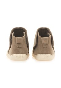 Stivaletti alla caviglia in suede marrone con una texture liscia, dotati di un'etichetta sul retro e di una suola in gomma beige. Design minimalista, senza decorazioni.