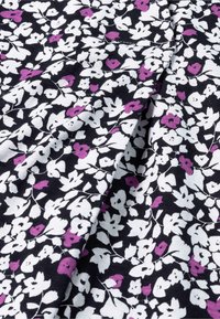 Blumenerstoff mit schwarzem Hintergrund, auf dem weiße und lila Blumen in einem sich wiederholenden Muster abgebildet sind. Weiche Textur und leichtes Material.