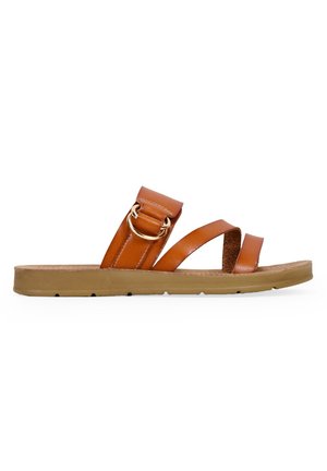 Sandal in pelle marrone con tre cinghie, una delle quali presenta un accento circolare dorato, e una suola in gomma texturizzata color tan.