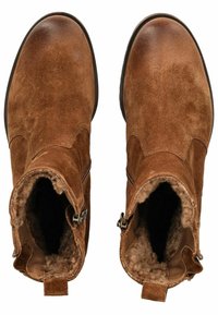 Botas de ante marrón hasta el tobillo con forro de piel de borrego, cierres de cremallera en los laterales, punta redondeada y superficie superior texturizada. Lengüetas en la parte posterior.