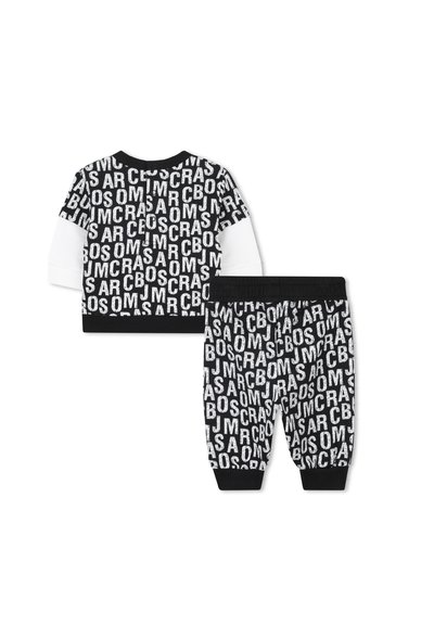 Completo per bambini in bianco e nero, composto da una maglietta a maniche lunghe con stampe di lettere e pantaloni coordinati con polsini elastici. Materiale misto cotone.