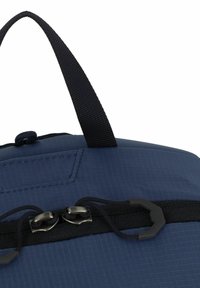 Marineblauwe stoffen tas met een gestructureerd oppervlak, voorzien van een handvat aan de bovenkant, een ritssluiting met twee metalen ritsen en een klein buitenvak.