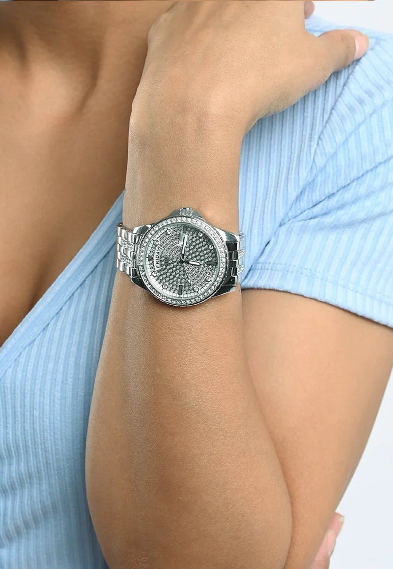 Srebrny zegarek z okrągłą, wysadzaną twarzą, teksturowanym szarym cyferblatem, srebrną bransoletą, wyświetlaczem daty i luminescencyjnymi znacznikami godzin.