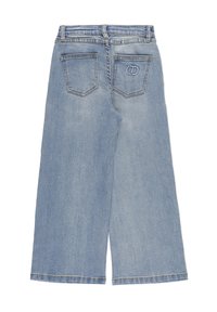 Jeans in denim blu chiaro con gamba larga, dotati di due tasche posteriori, una delle quali con un logo circolare ricamato, disposti su uno sfondo bianco.