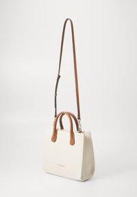 Off-white canvas håndtaske med brune læderhåndtag og en aftagelig skulderrem, der har et minimalistisk design og logo-detalje.