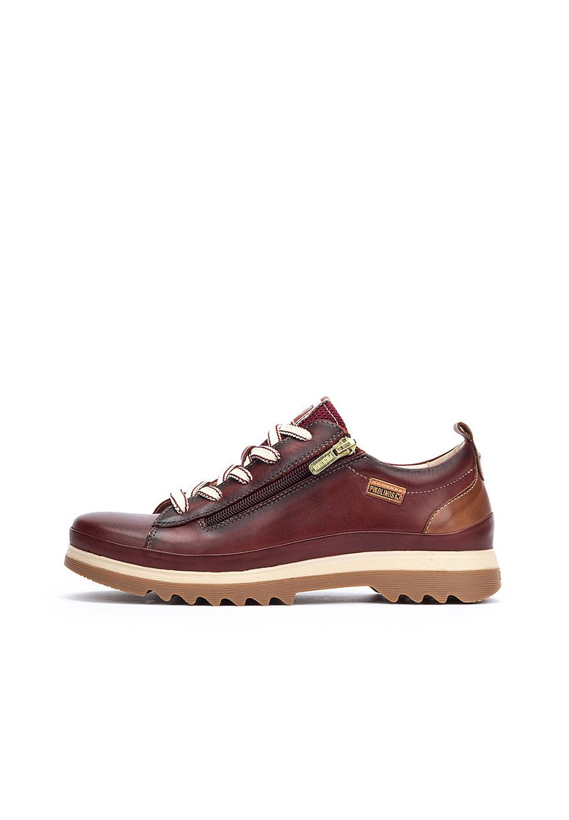 Scarpa in pelle bordeaux con dettagli in marrone chiaro, chiusura con zip e lacci bianchi. Suola testurizzata con scanalature profonde per la trazione.