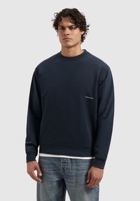 Navyblauwe sweatshirt van een zachte stof, met een ronde halslijn en geribde manchetten, met het 'PURE PATH' logo in het wit op de voorkant.
