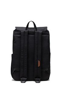 Black canvas backpack with padded shoulder straps, top handle, and a brown leather accent. Features a flap closure and side pockets.