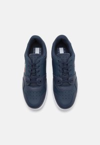 Scarpe da ginnastica blu navy con tomaia in pelle, accenti in rete, punta forata per traspirabilità e suola in gomma bianca. Presentano un design con lacci.
