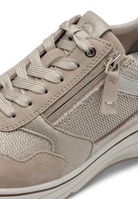 Scarpa sportiva beige realizzata in mesh e suede, con una zip decorativa sul lato, lacci piatti e una suola texturizzata.