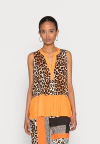 Top sem mangas com estampa de leopardo e bainha peplum em laranja brilhante, com decote em V e acabamento em laranja em contraste. Tecido leve.