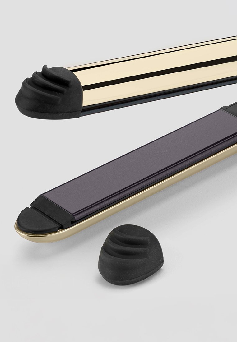 Dwa prostowniki do włosów z złotymi i czarnymi akcentami; jeden z nich ma matowe, ciemnofioletowe body. Obejmuje teksturowane gumowe końcówki.