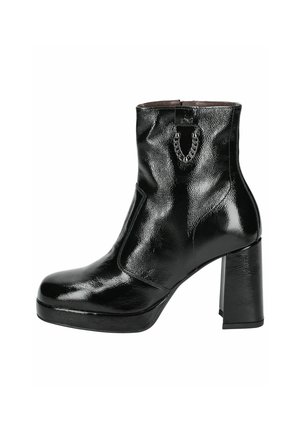 Bottines noires en cuir verni brillant, avec un talon épais, une plateforme, et un accent en chaîne à l'avant pour les détails.