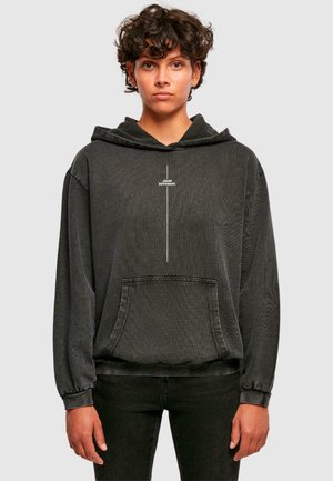Black hooded sweatshirt with a front pocket, textured fabric, and a white printed logo. Features dropped shoulders and ribbed cuffs.