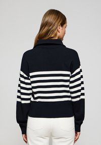 Randig pullovertröja i marinblått och vitt stickat tyg, med vikt krage, långa ärmar och ribbad nederkant.