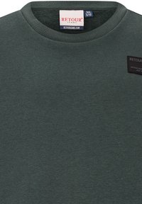 Felpa verde a girocollo realizzata in un tessuto dalla consistenza morbida. Presenta un patch logo nero sul fronte e un collo a coste.