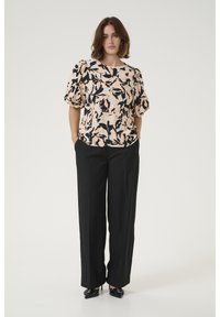 Blusa con motivo floreale nei colori pesco, nero e crema, dotata di maniche a sbuffo e scollo rotondo, abbinata a pantaloni neri su misura.