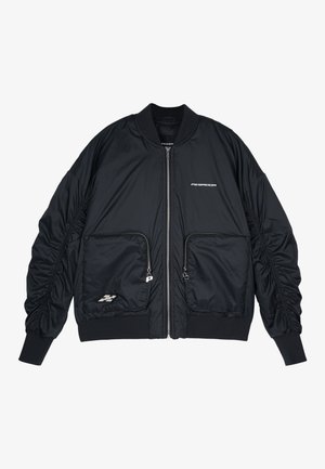 Crna bomber jakna s patentnim zatvaračem sprijeda, rebrastim manžetama i rubom. Ima dva prednja džepa, nabrane rukave i detalje s srebrnim logotipom.
