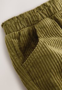 Olijfgroene corduroy broek met een geribbelde structuur, elastische tailleband en zijzakken voor extra functionaliteit.