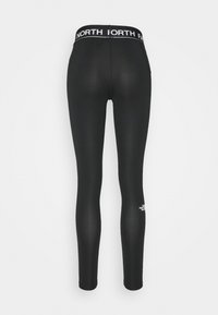 Leggings noirs en matériau extensible, dotés d'une taille haute avec le texte "NORTH FACE" en blanc et un petit logo près de la cheville.