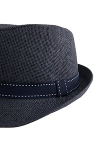 Grå vävd hatt med en strukturerad form, prydd med ett marinblått band med vit söm. Slät textur på skärmen.