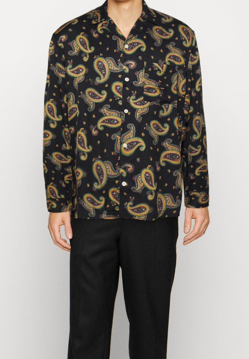 Camisa negra de manga corta con un colorido patrón de paisley, hecha de una tela suave, con cierre de botones en la parte delantera y un bolsillo en el pecho.