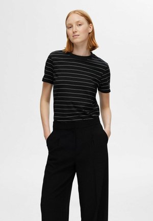 Black short-sleeve t-shirt featuring white horizontal stripes, made from soft fabric. Paired with black high-waisted wide-leg trousers.
