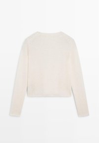 Maglione lungo a maniche lunghe di colore crema, con scollo rotondo, visto da dietro, che presenta una trama a maglia leggermente morbida.