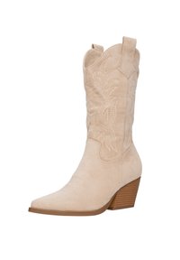 Bota de cowboy de ante beige con punta afilada, detalles bordados en el eje y tacón apilado. Cuenta con tiradores para facilitar el uso.
