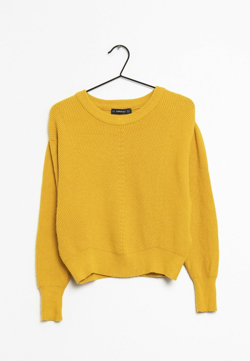 Pull à côtes jaune avec un col rond, des épaules tombantes et un ourlet court. Le tissu présente un motif tricoté texturé.