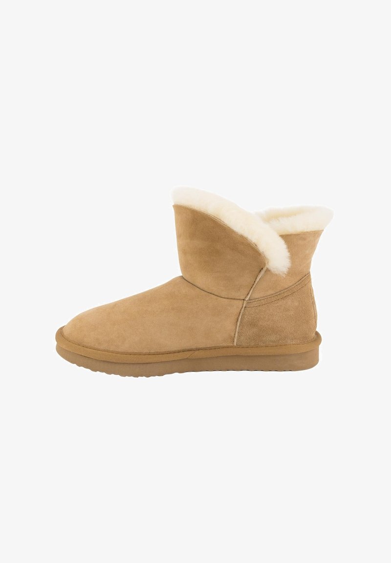 Tan suède enkelboot met een oprolbare faux fur manchet. Rond neus en platte rubberen zool. Soepele textuur met stikseldetails.