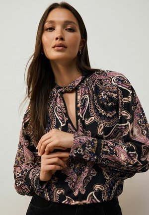 Blusa nera con un motivo paisley colorato, dettaglio al collo con laccetto, maniche lunghe e polsini con bottoni, realizzata in tessuto leggero.