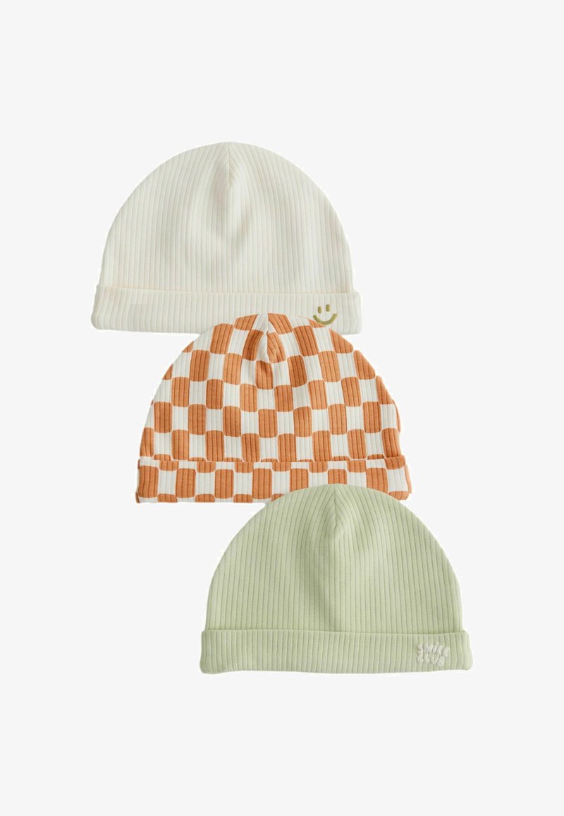 Trois bonnets en maille côtelée crème avec un visage souriant, un damier orange et blanc et un vert clair avec un petit logo brodé.