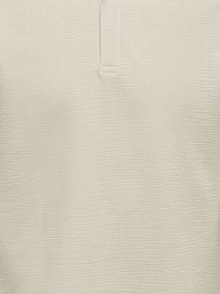 Bež tkanina teksture s malim uzdignutim pravokutnim uzorkom i okomitim šavom koja završava u vodoravnom detalju šavova u sredini.