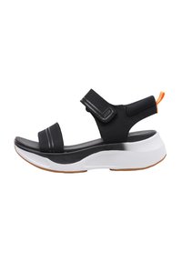 Sandalia deportiva negra con correas de Velcro ajustables, parte superior negra texturizada, media suela blanca y suela de goma con un tirador naranja.