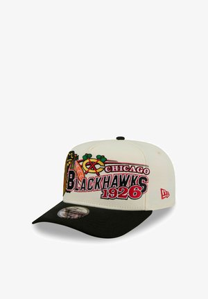 Gorra blanca y negra de los Chicago Blackhawks con logo bordado, texto "Chicago Blackhawks 1926" y logo de New Era en el lateral.