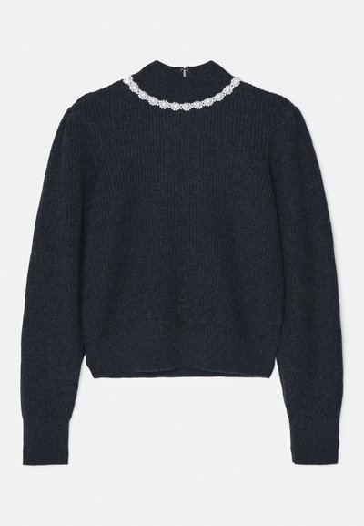 Pull en maille côtelée bleu marine foncé avec des manches longues et un col montant, décoré d'un détail de collier floral à perles blanches au niveau du col.