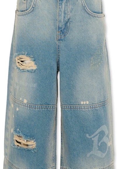 Shorts en jean bleu clair avec des trous usés et des patchs cousus, présentant des détails de tissu décoloré et usé.